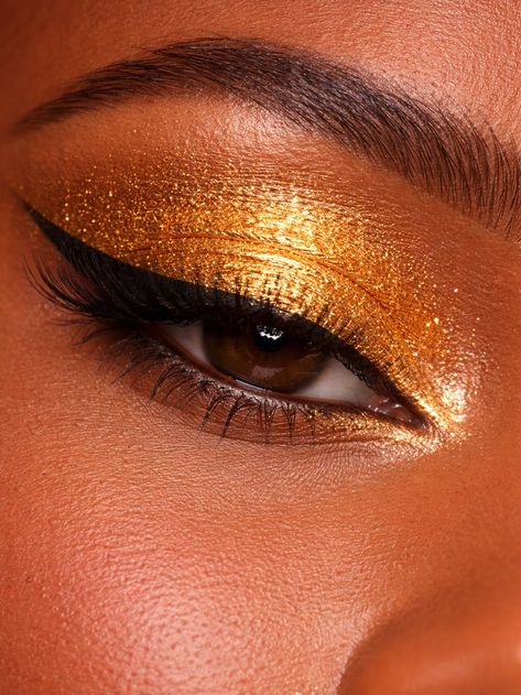 Close-up of a person's eye with gold glitter makeup