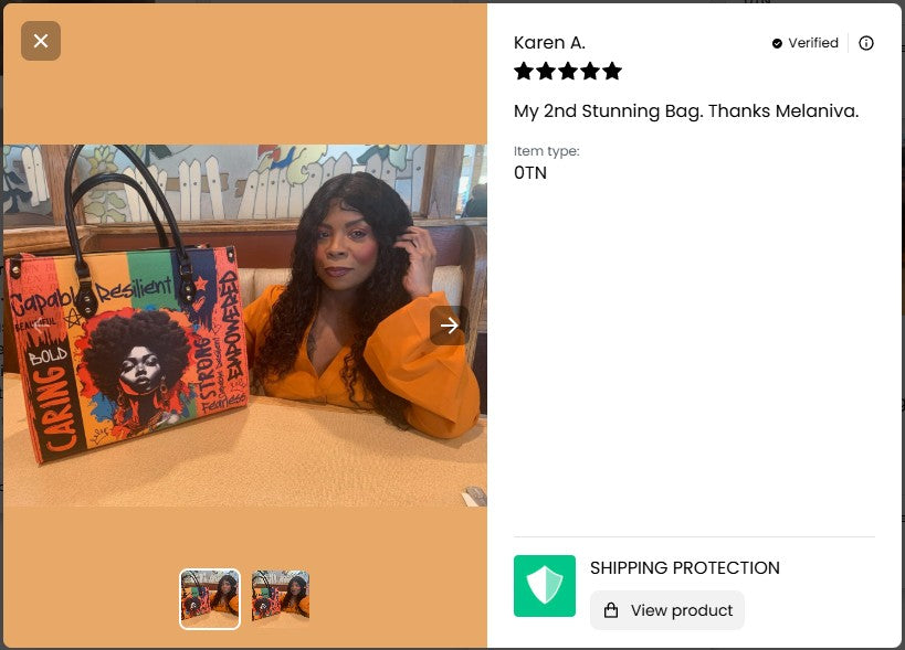 Person holding a colorful bag with text, sitting next to it on a table.